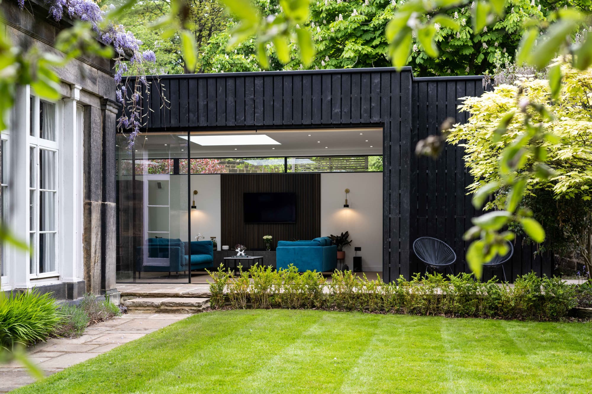 Modern black timber clad extension to a Grade II listed building, Leeds